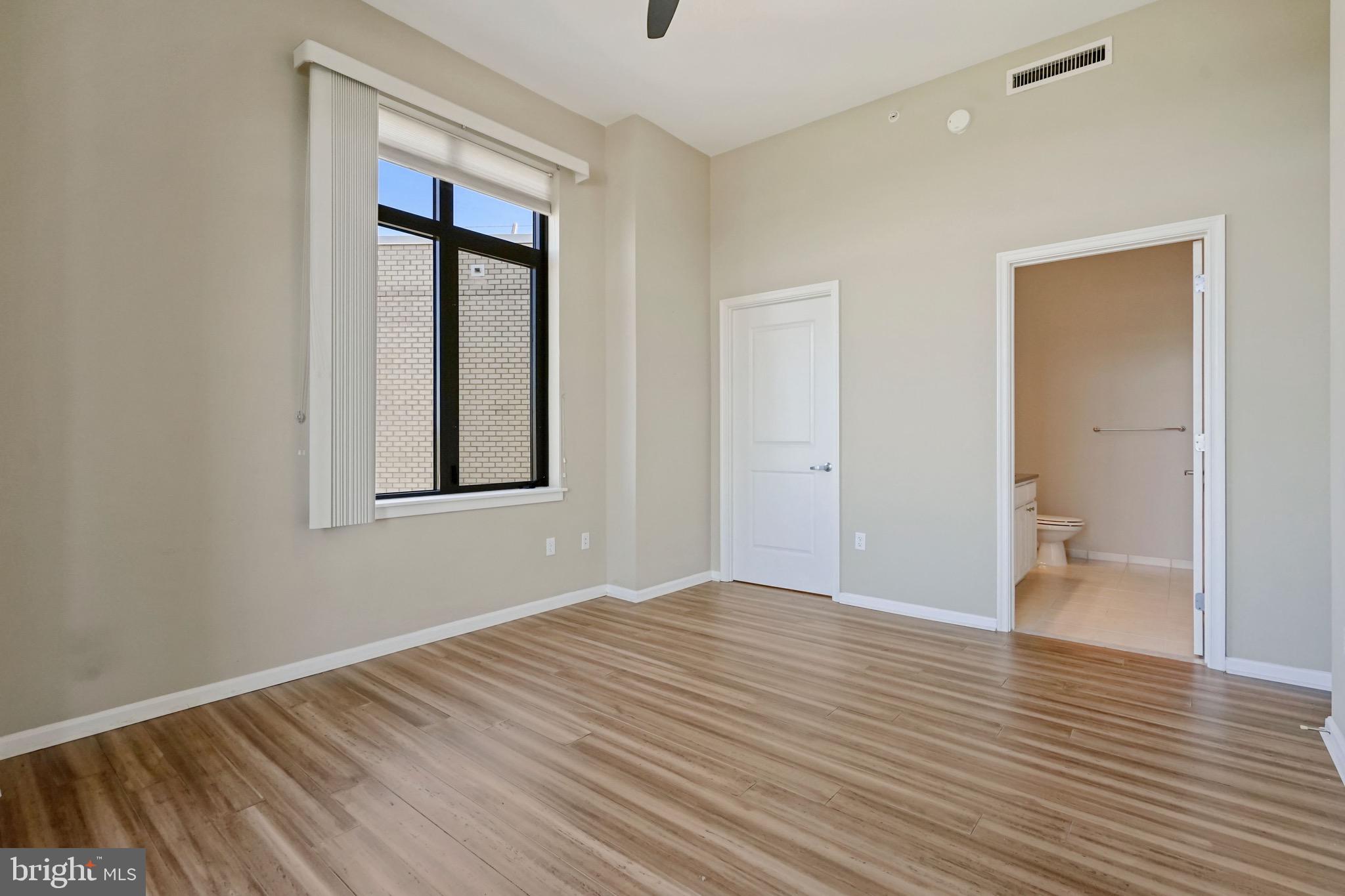 2720 South Arlington Mill Drive, Unit 1102 Arlington, VA 22206 - Photo 15 of 28 a view of an empty room with wooden floor and a window