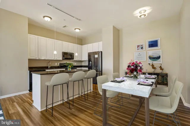 a kitchen with kitchen island granite countertop a sink cabinets and stainless steel appliances
