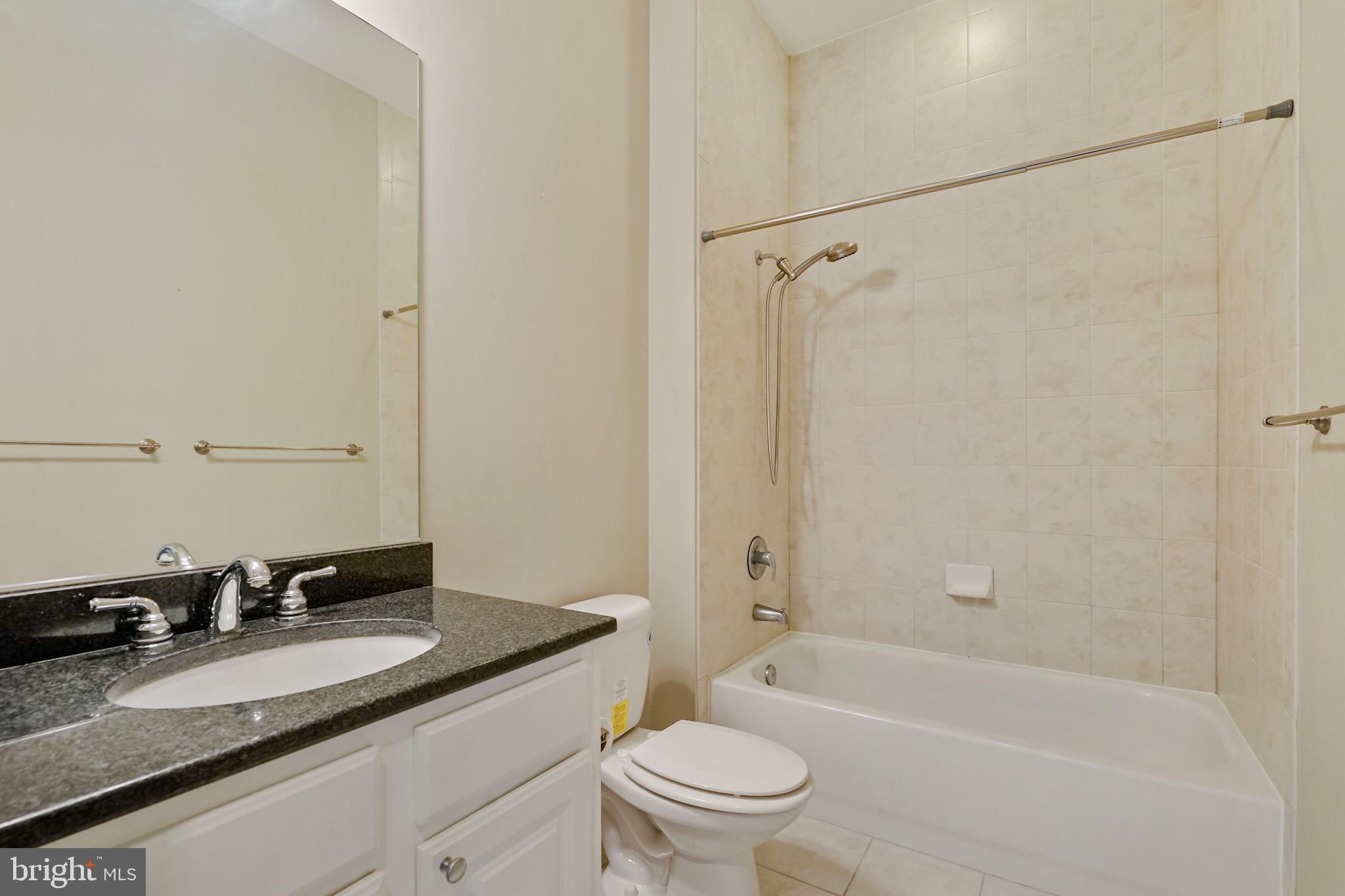 2720 South Arlington Mill Drive, Unit 1102 Arlington, VA 22206 - Photo 23 of 28 a bathroom with a granite countertop sink toilet and shower