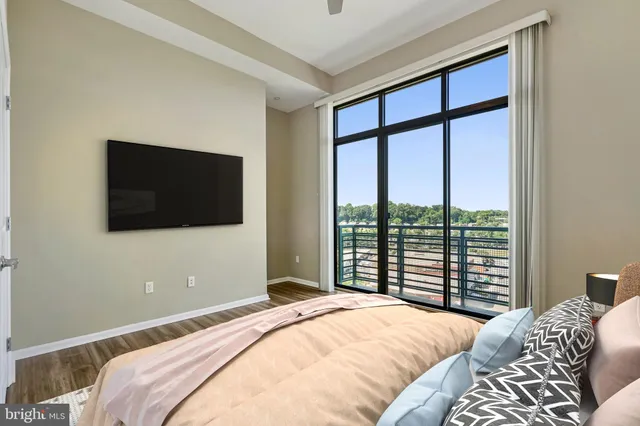 a bedroom with a large bed and a flat tv screen