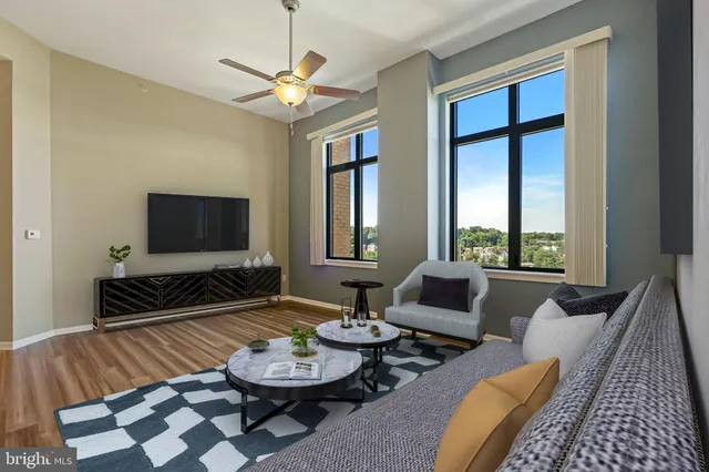 a living room with furniture a flat screen tv and a large window