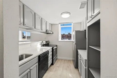 a kitchen with stainless steel appliances granite countertop a refrigerator a stove and a sink