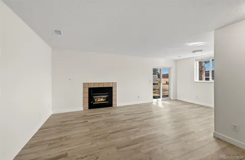 a view of an empty room with a fireplace and a window