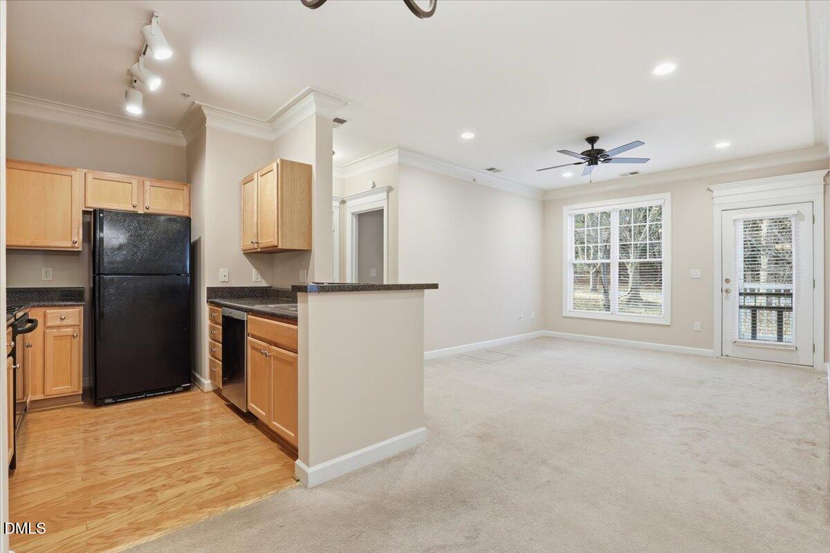 1301 Durlain Drive, Unit 208 Raleigh, NC 27614 - Photo 10 of 28 a kitchen with stainless steel appliances kitchen island granite countertop a refrigerator and a sink