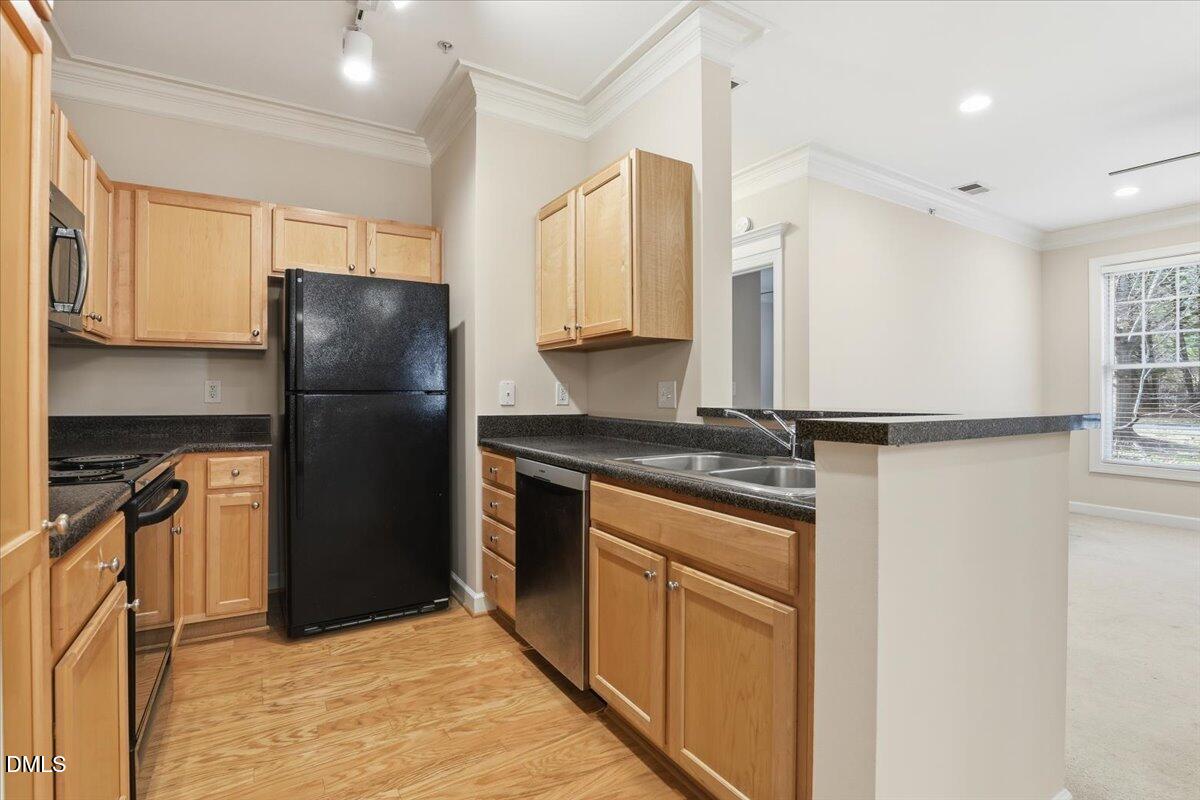 1301 Durlain Drive, Unit 208 Raleigh, NC 27614 - Photo 12 of 28 a kitchen with stainless steel appliances granite countertop a refrigerator and a sink