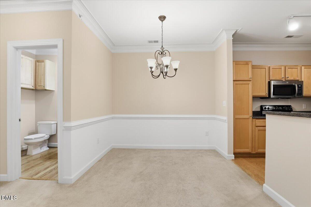 1301 Durlain Drive, Unit 208 Raleigh, NC 27614 - Photo 14 of 28 a view of a room with wooden floor and a chandelier