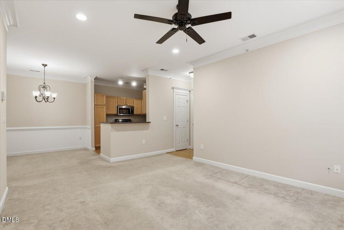 1301 Durlain Drive, Unit 208 Raleigh, NC 27614 - Photo 7 of 28 an empty room with a kitchen and a ceiling fan