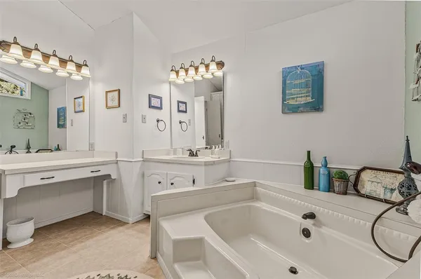 a bathroom with a tub sink and mirror