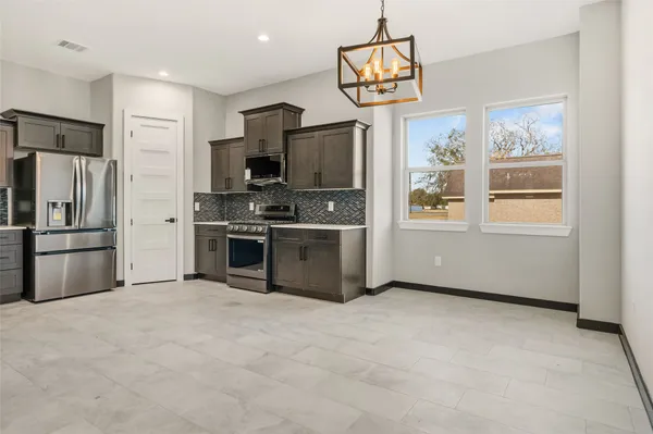 a kitchen with stainless steel appliances a refrigerator and a stove top oven