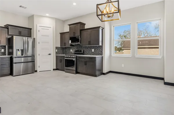a kitchen with stainless steel appliances a stove a refrigerator and a sink