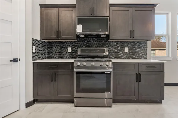 a kitchen with stainless steel appliances granite countertop a stove and a microwave