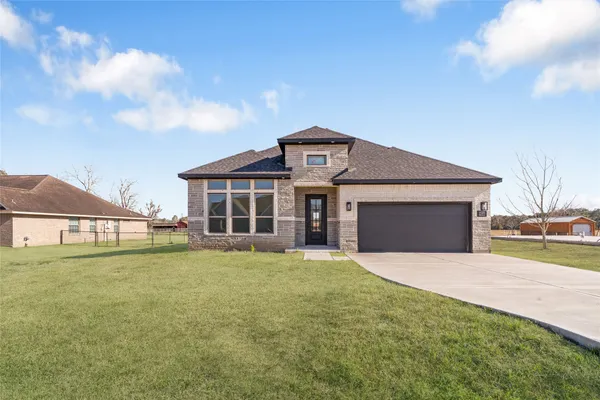 a front view of a house with a yard and garage