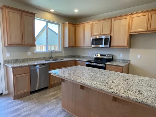 a kitchen with granite countertop wooden cabinets a sink and dishwasher