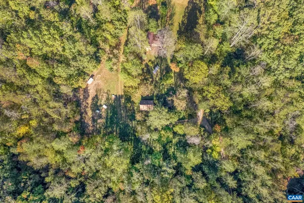 an aerial view of residential houses with outdoor space and trees