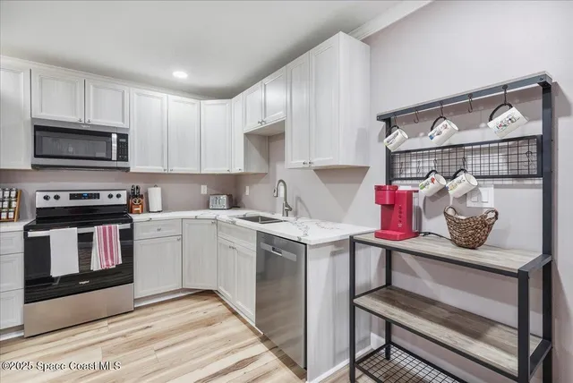 a kitchen with a sink and wooden floor