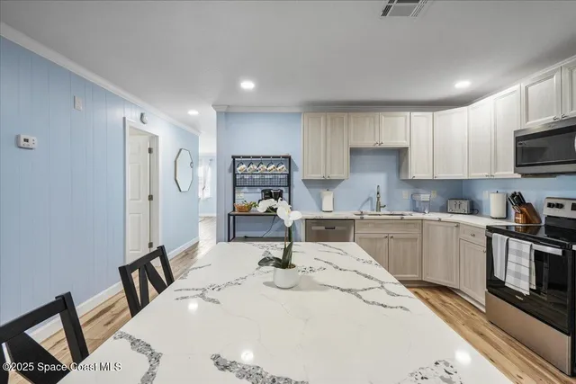 a kitchen with stainless steel appliances kitchen island granite countertop a refrigerator sink and cabinets