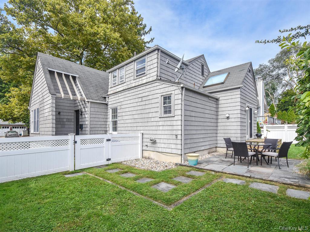 20 Oldwood Road South, Unit 1 Port Washington, NY 11050 - Photo 16 of 20 a backyard of a house with table and chairs
