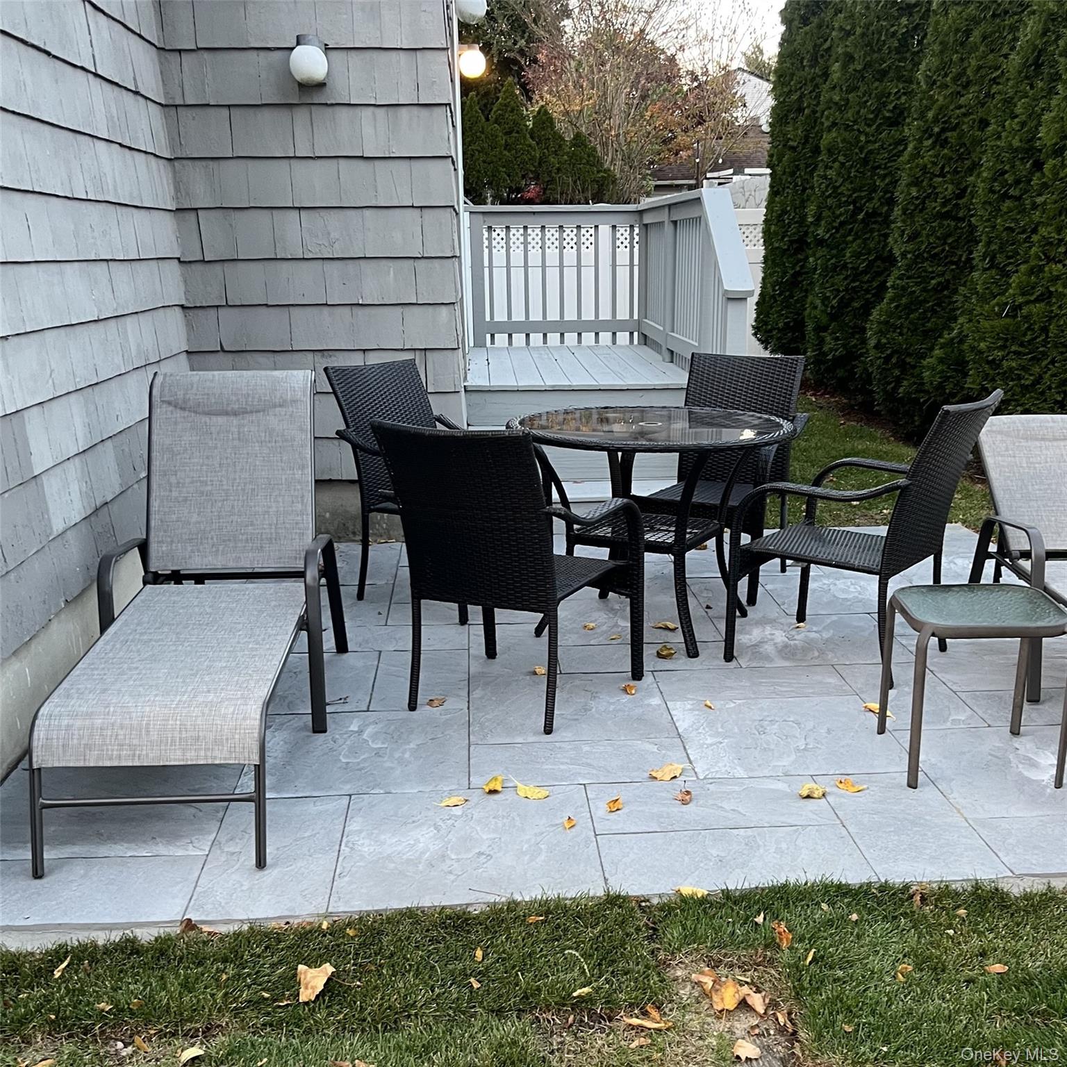 20 Oldwood Road South, Unit 1 Port Washington, NY 11050 - Photo 17 of 20 a view of a tables and chairs in back yard of the house