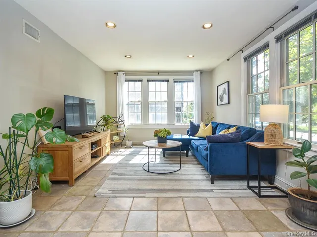 a living room with fireplace furniture and a potted plant