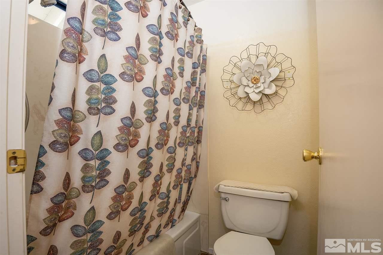 1235 Conway Lane Reno, NV 89503 - Photo 17 of 37 a white toilet sitting next to a shower curtain