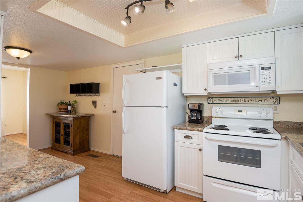 1235 Conway Lane Reno, NV 89503 - Photo 6 of 37 a kitchen with appliances a refrigerator and a stove top oven