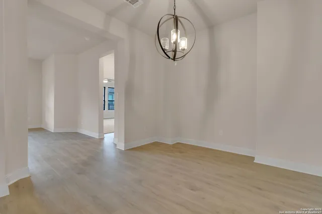 an empty room with wooden floor and mirror