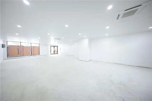 a view of empty room with kitchen