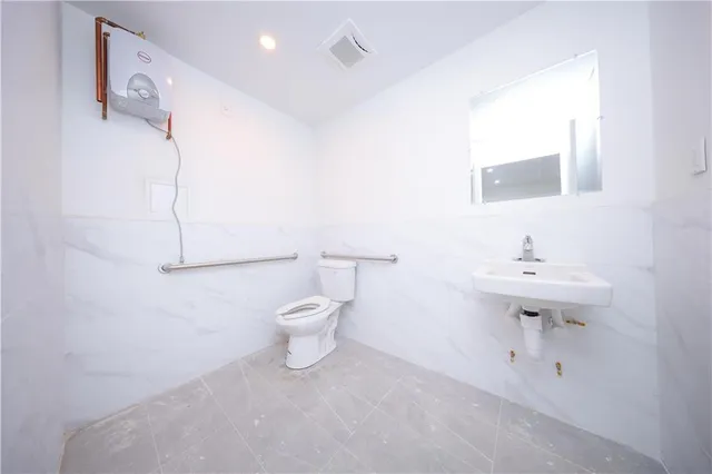 an empty room with a cabinet and mirrors