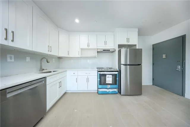 a view of a big room with wooden floor and a window