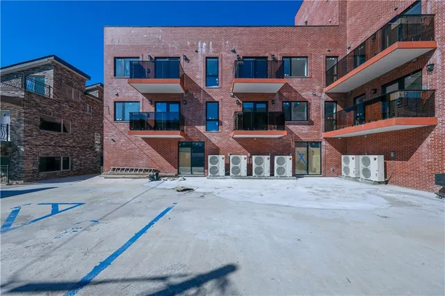 a front view of a building with a garden and plants