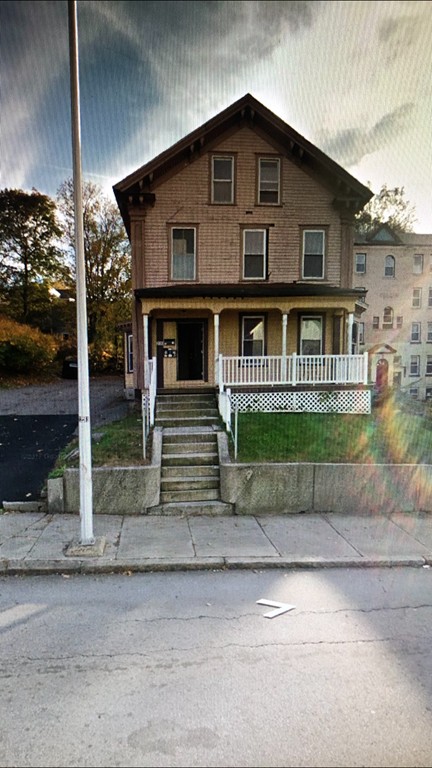 a front view of a house with a yard and potted plants