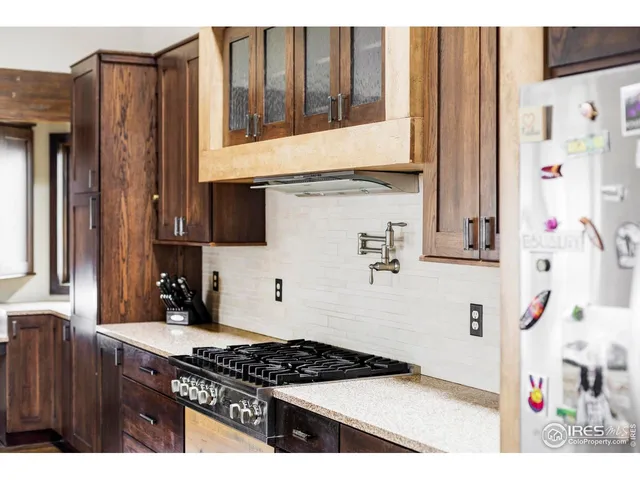 a kitchen with stainless steel appliances a sink a stove a refrigerator and cabinets