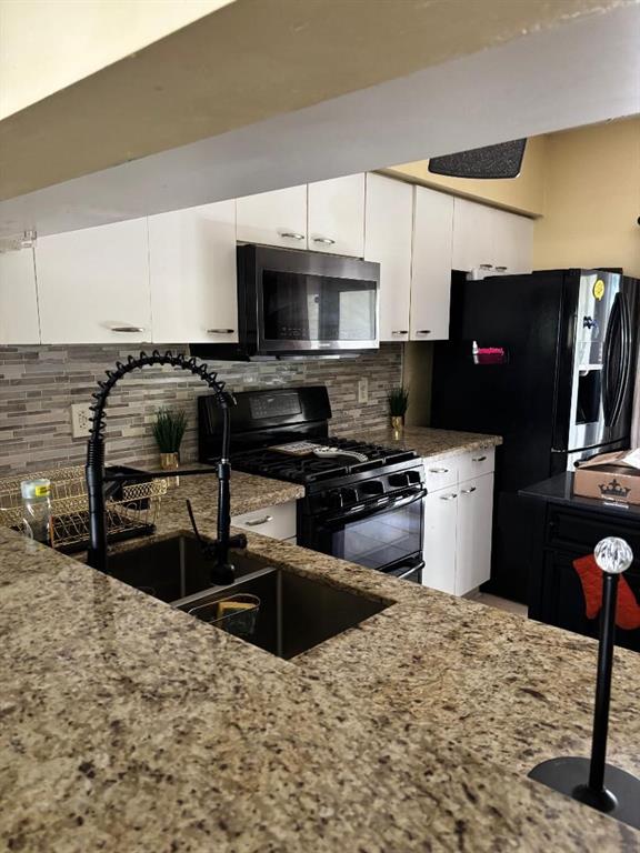 11050 Conch Court Tamarac, FL 33321 - Photo 10 of 17 a kitchen with stainless steel appliances kitchen island granite countertop a stove a sink and a microwave