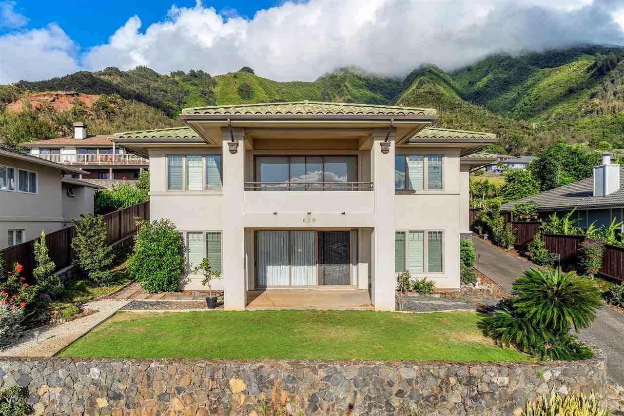 a view of a white house with a big yard and potted plants