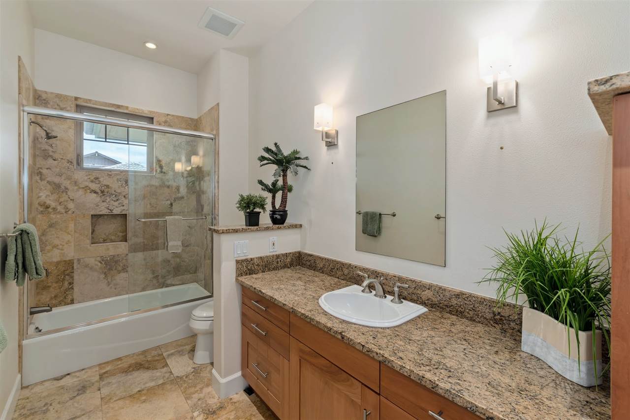 620 Mapuana Place Wailuku, HI 96793 - Photo 21 of 30 a bathroom with a granite countertop sink a mirror a bathtub and shower