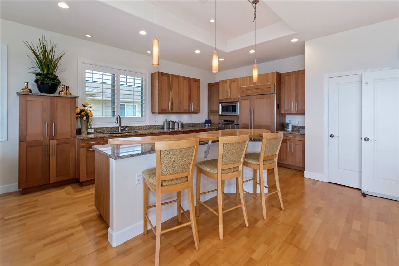 620 Mapuana Place Wailuku, HI 96793 - Photo 4 of 30 a kitchen with stainless steel appliances kitchen island granite countertop a refrigerator a stove a microwave oven a sink with island and chairs
