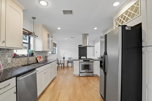 a kitchen with stainless steel appliances granite countertop a refrigerator sink and stove
