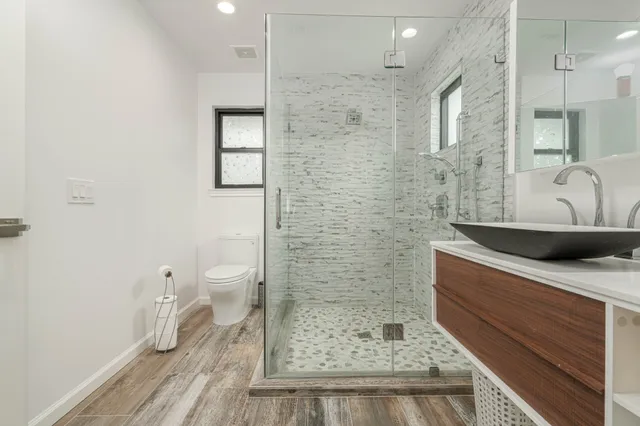 a bathroom with a sink a toilet and shower