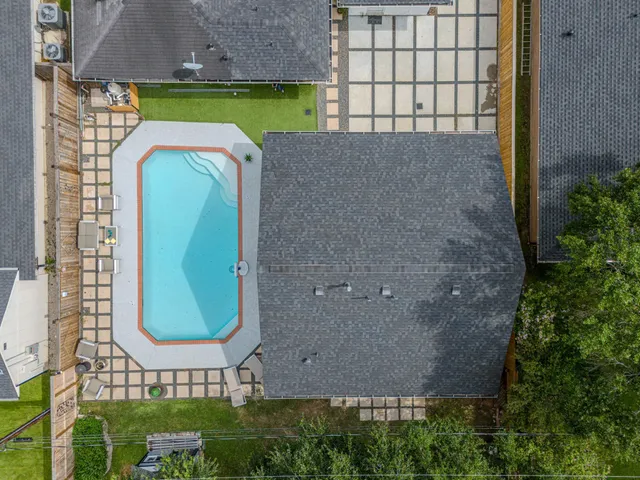 an aerial view of a house with a swimming pool and a yard