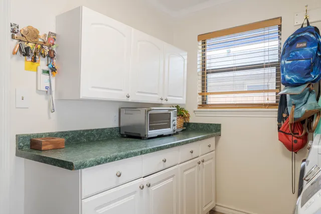 a kitchen with granite countertop white cabinets and window