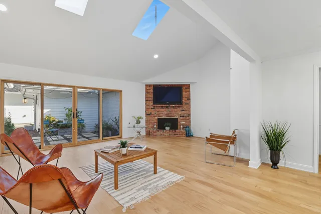 a living room with fireplace furniture and a floor to ceiling window