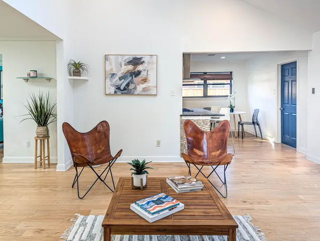 a living room with furniture a wooden floor and next to a window