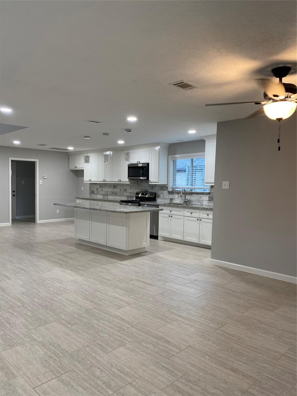 1622 Fall Valley Drive Houston, TX 77077 - Photo 8 of 10 a large kitchen with stainless steel appliances granite countertop a stove a sink and a microwave