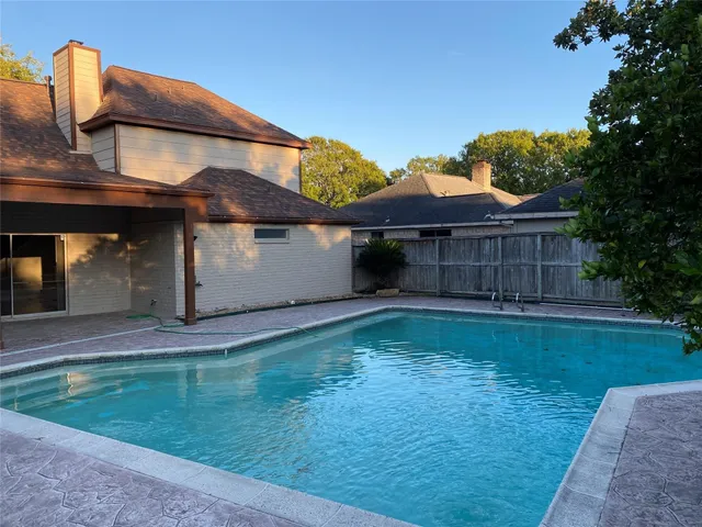 a view of a house with a yard plants and large tree