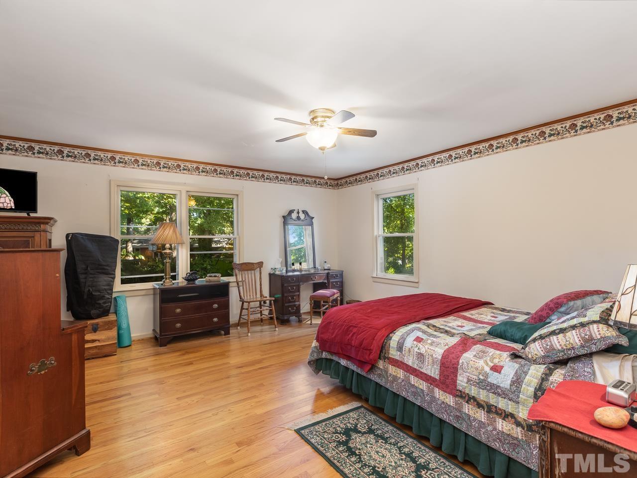 3205 Fairforest Place Raleigh, NC 27604 - Photo 17 of 28 a bedroom with a bed and a dresser with wooden floor
