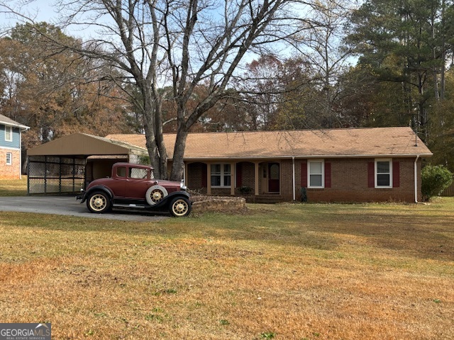 a view of a house with a yard and parking space