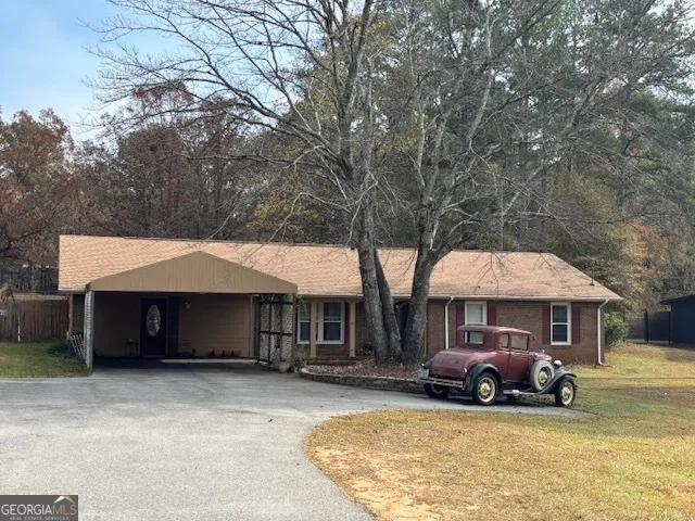 a view of a house with a yard and sitting area