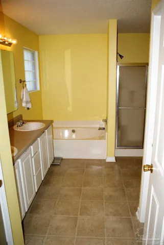 a bathroom with a granite countertop sink a mirror and a bathtub