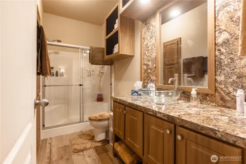 a bathroom with a granite countertop sink toilet and shower