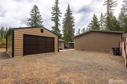 a backyard of a house with large trees and garage